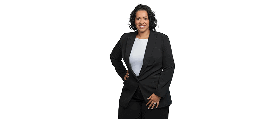 Professional woman in black suit smiling with hand on hip.