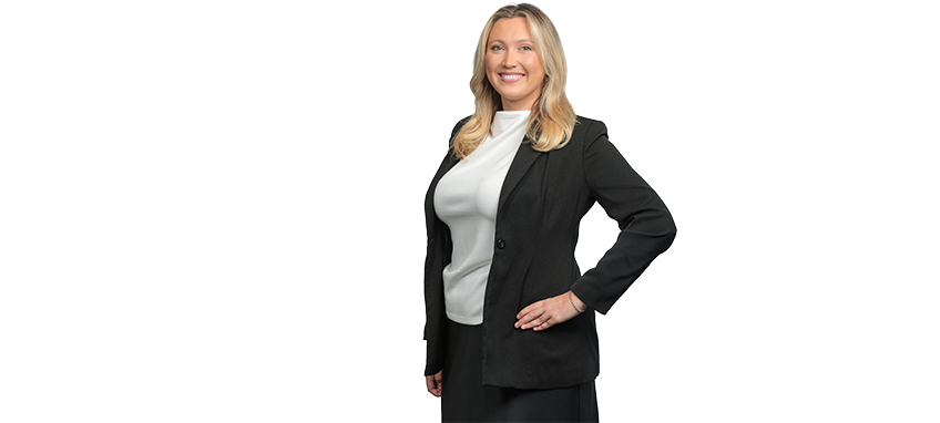 A smiling woman with blonde hair in a black blazer and white top.